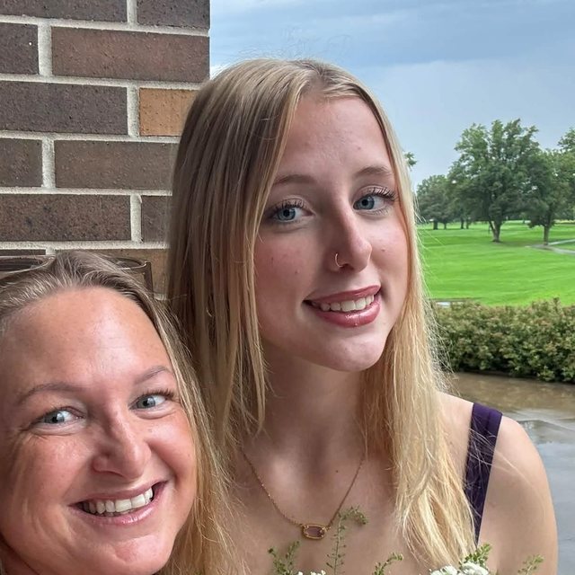 Audrey and Erin smiling outside on a cloudy day